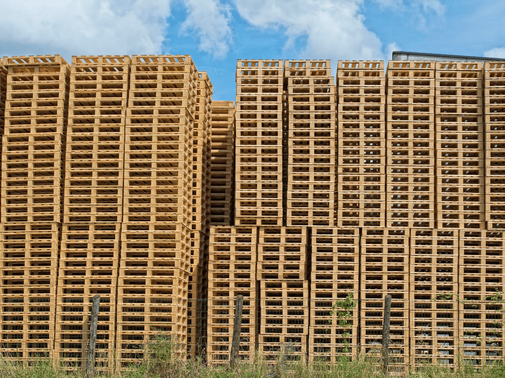 Torres altas de palets de madera almacenadas en las instalaciones de GreenPal